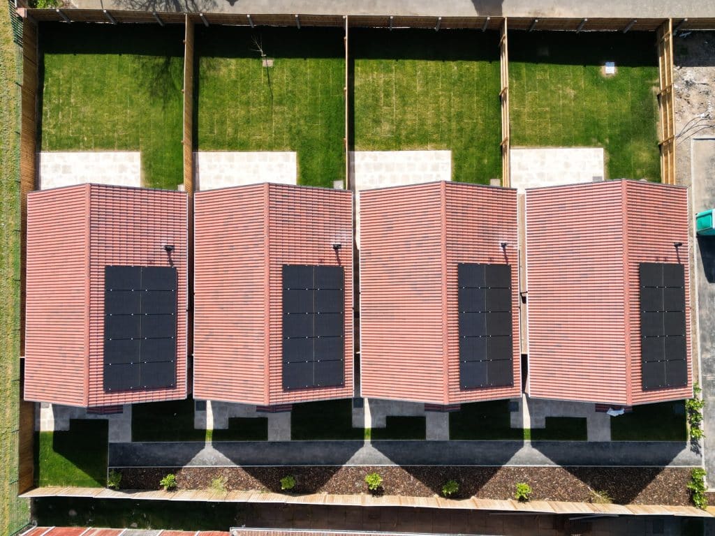 Terrace of new-build homes with solar panels on every roof, seen from above