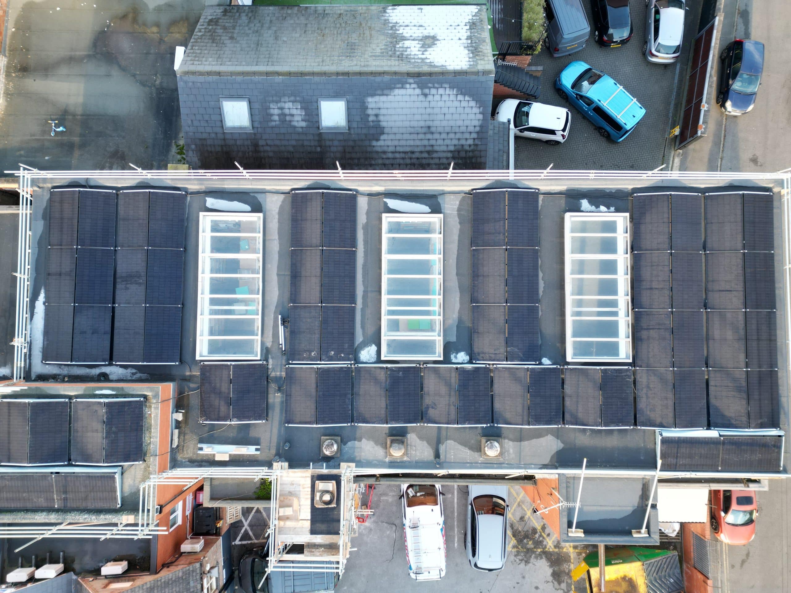 Aerial view of completed 35kW JA Solar panel array on commercial flat roof at Johns of Nottingham, Mapperley