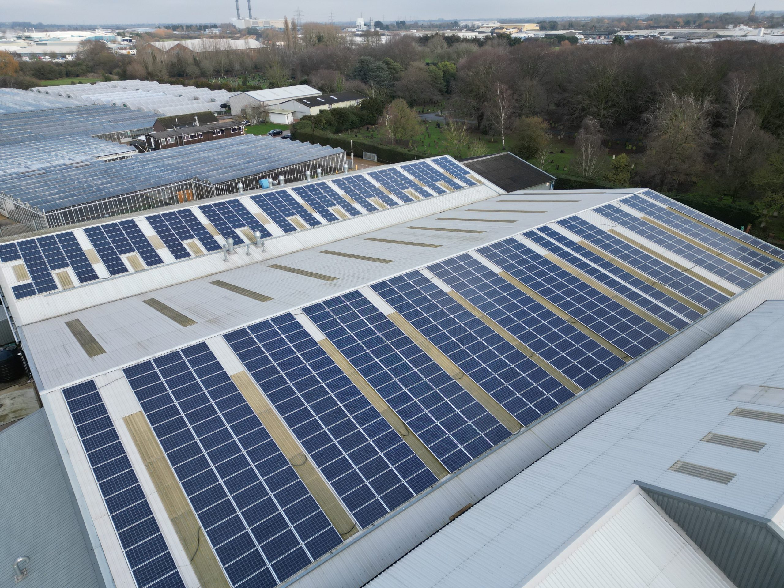 Completed 177kW commercial solar PV array on metal warehouse roof aerial view at Elsoms Seeds