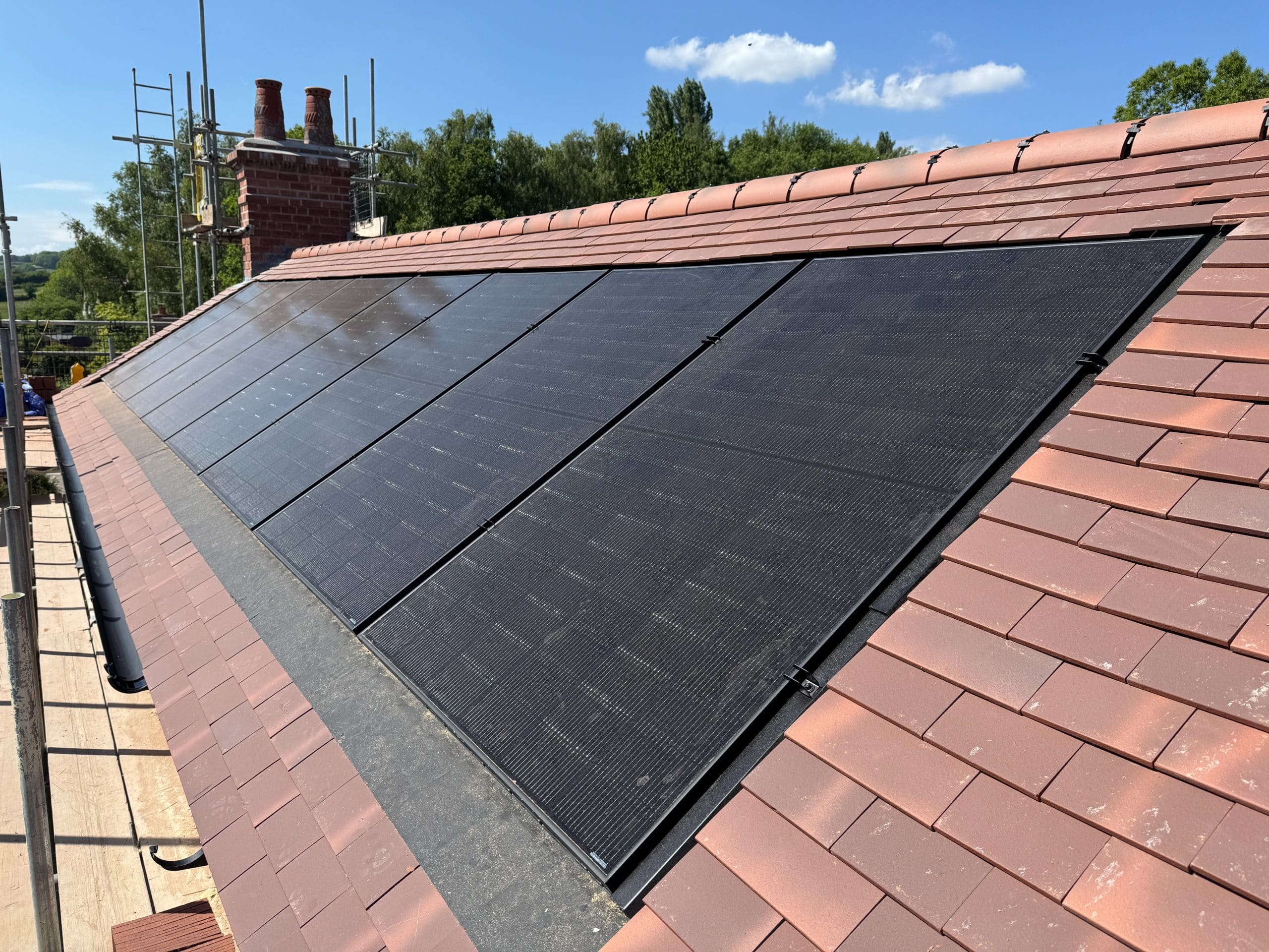 Close-up of completed GSE in-roof solar array showing flush integration of DMEGC 450W panels with roof tiles