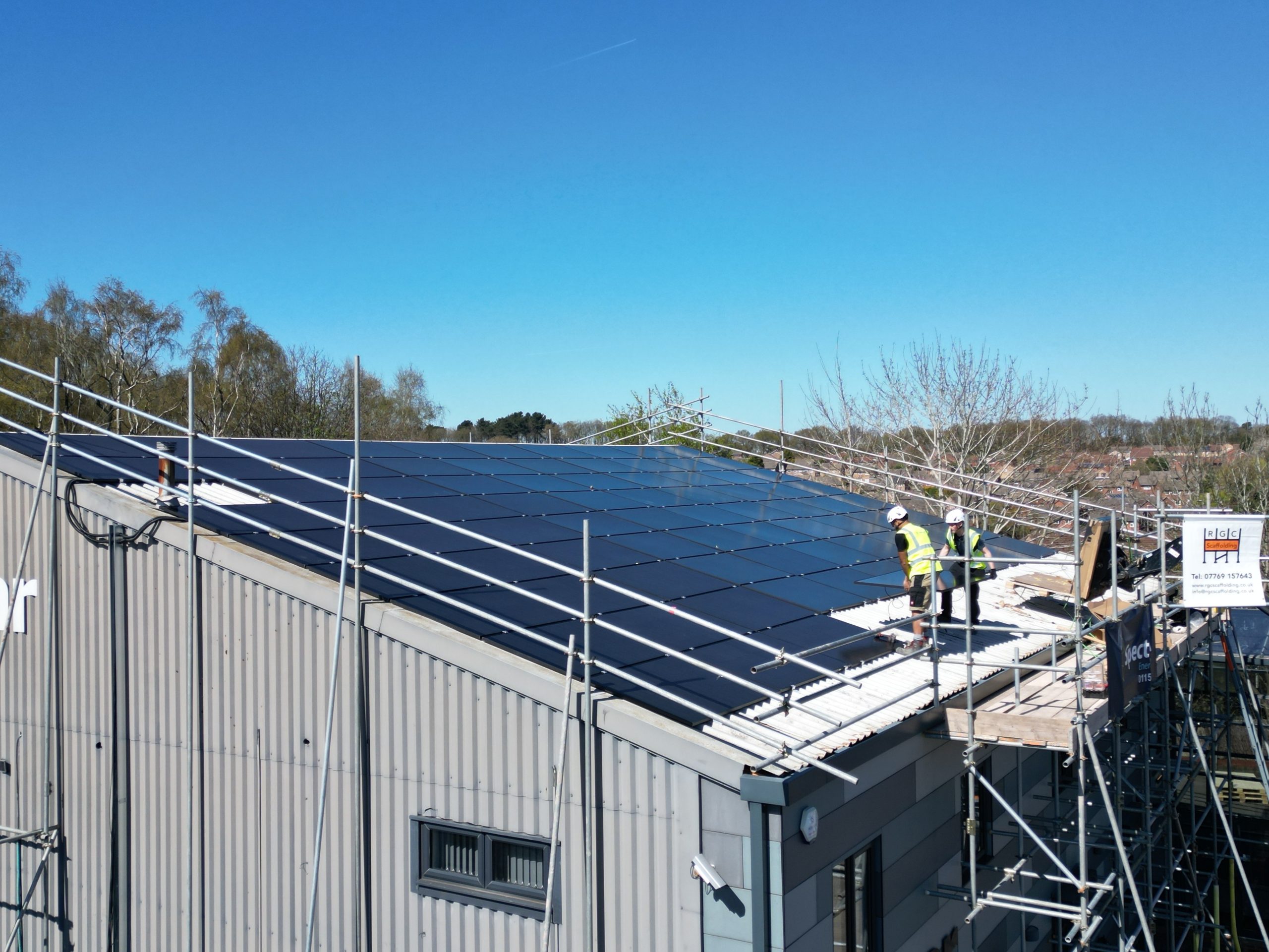 Commercial solar installation progress showing scaffolding and panel mounting at Linear Insulation