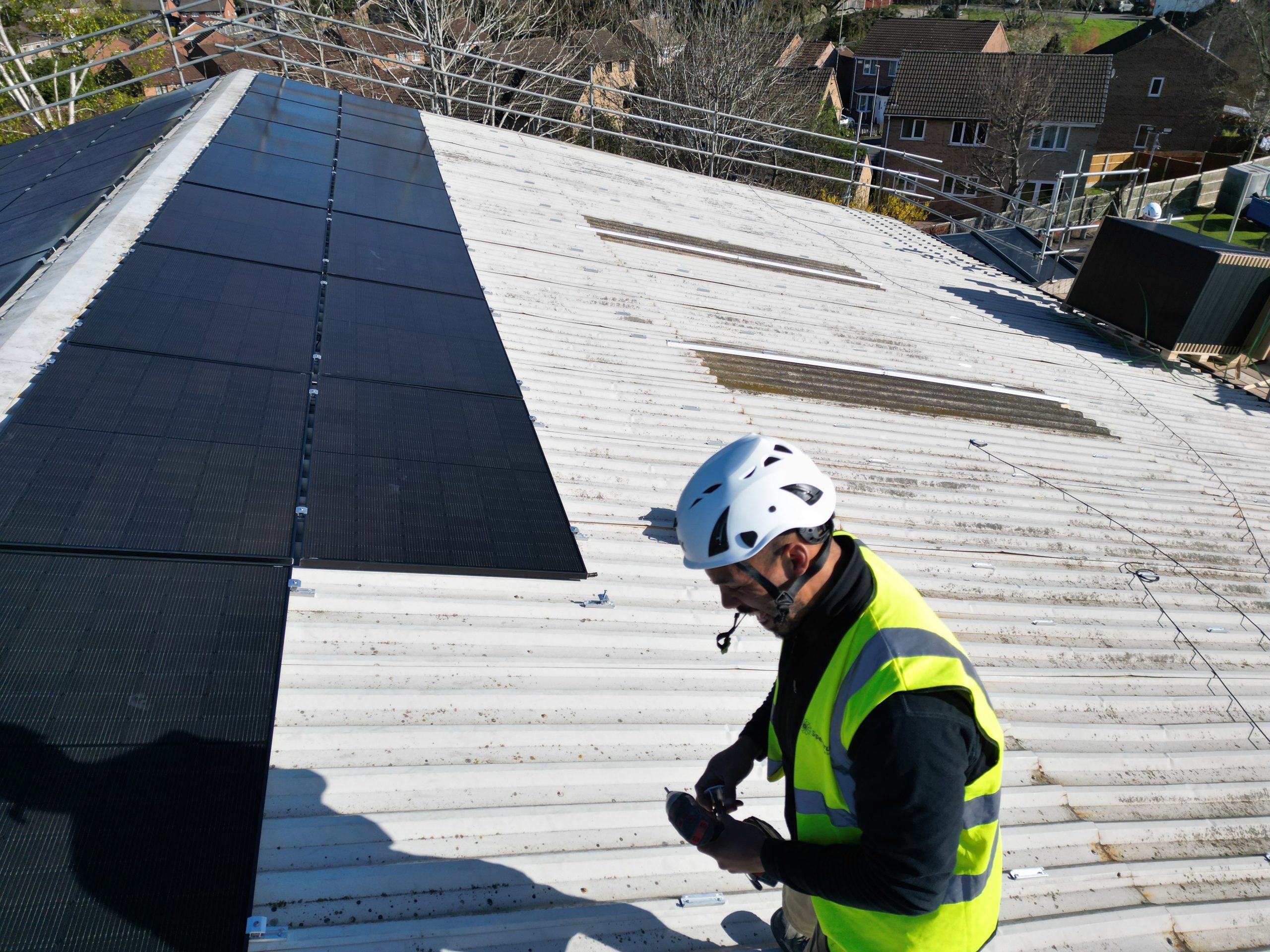 Installer fixing mounting clamps for JA Solar 455W panels on metal roof at Linear Insulation
