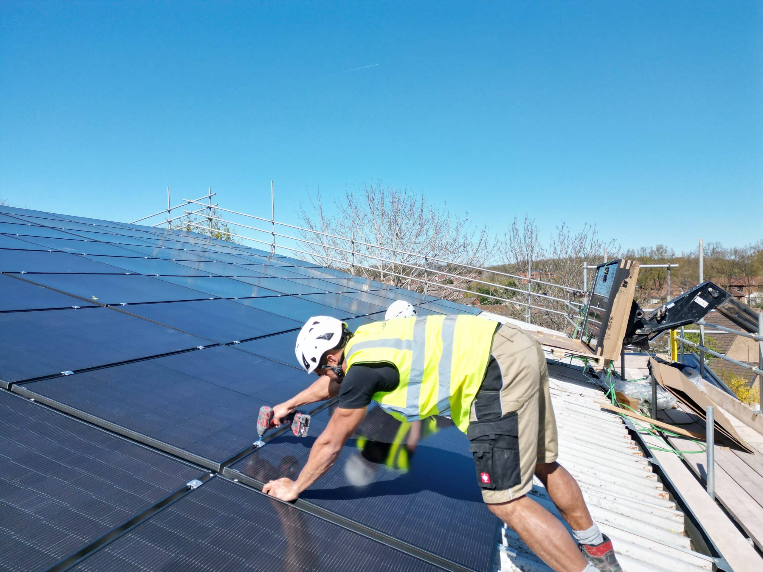 Solar panel repair technician inspecting residential roof system UK
