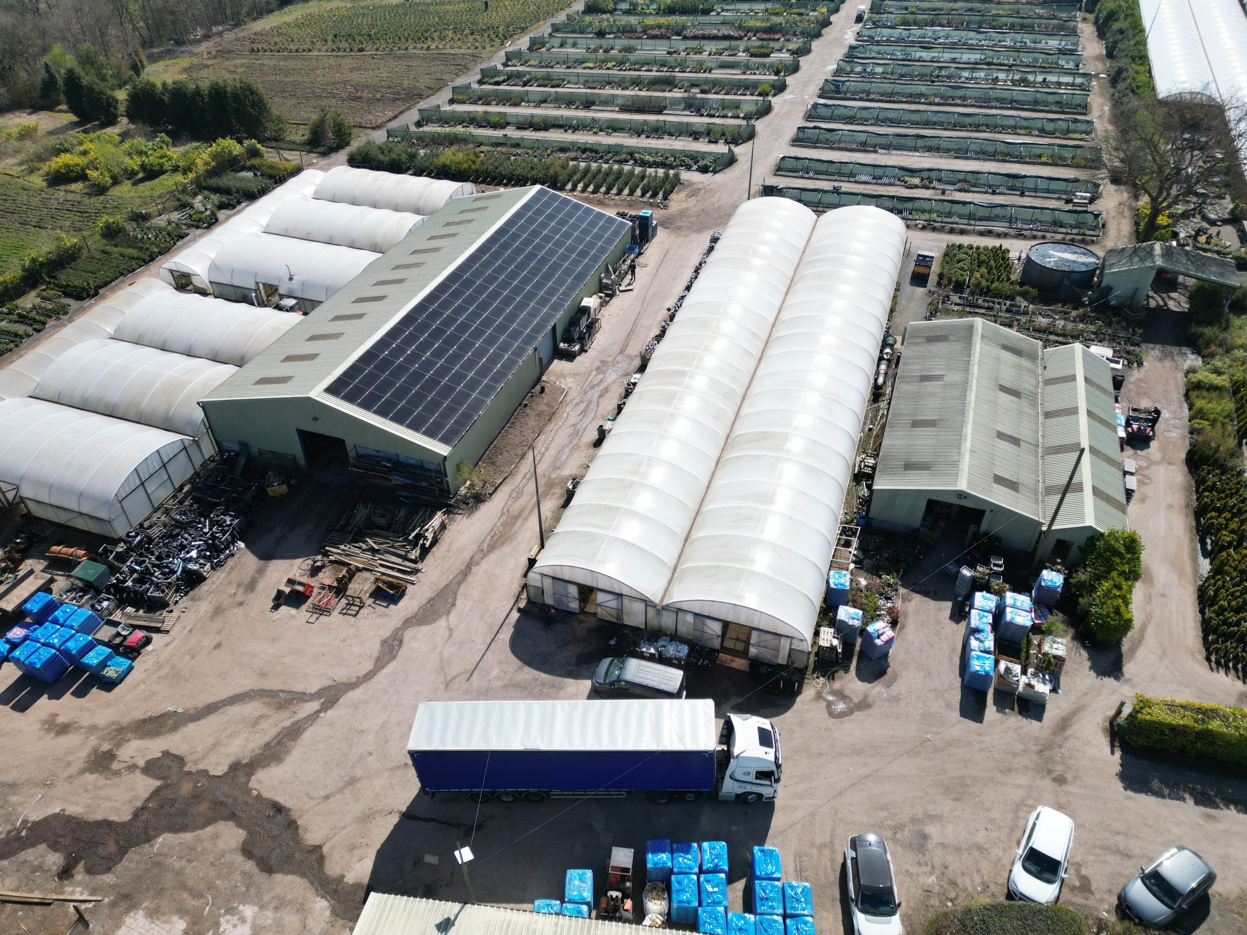 56kW Aiko 455W solar panel array on trapezoidal metal roof at Jacksons Nurseries garden centre - aerial overview