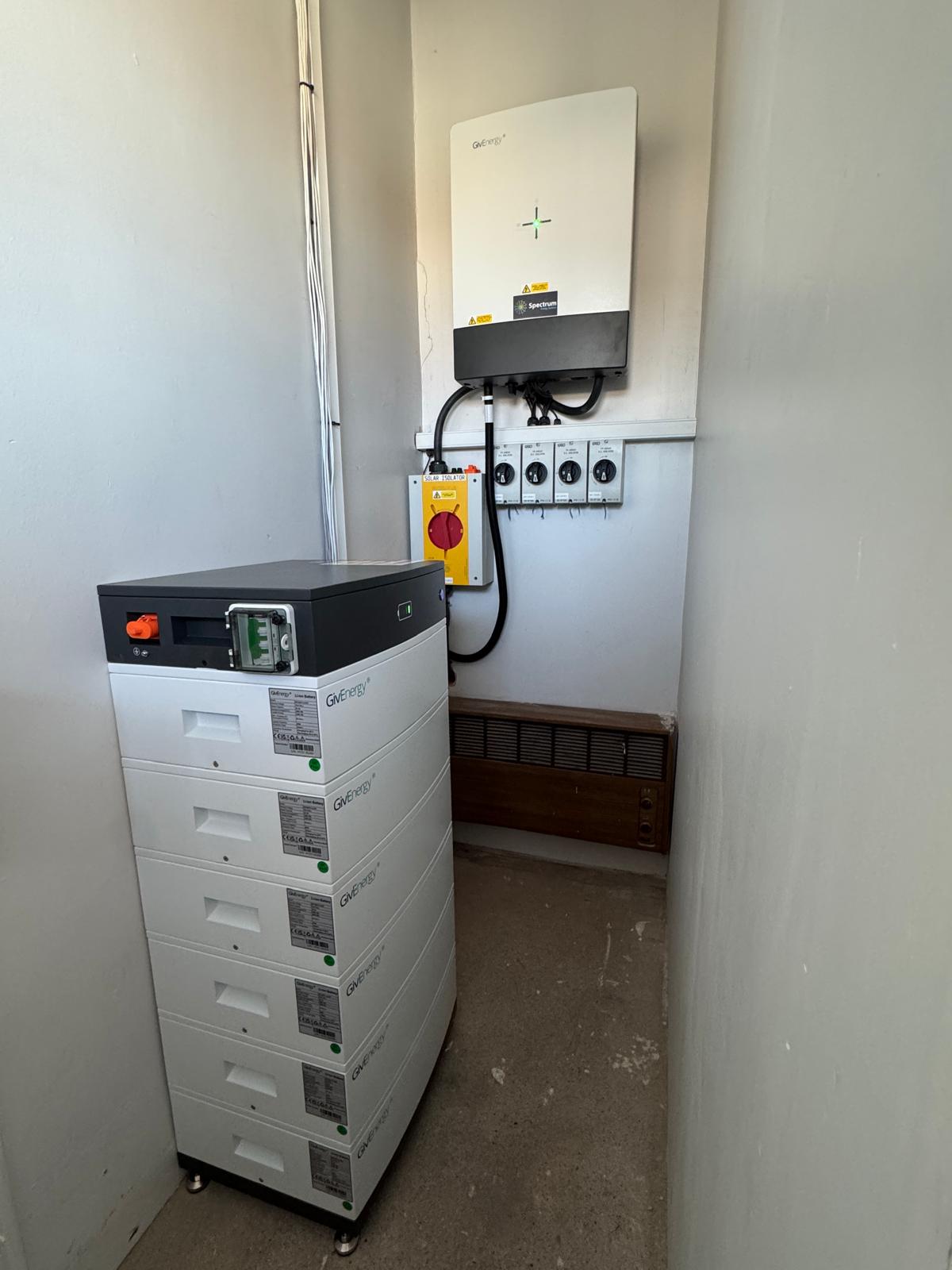 Commercial solar battery storage stack and hybrid inverter in a plant room at Johns of Nottingham (Spectrum Energy Systems UK installation)