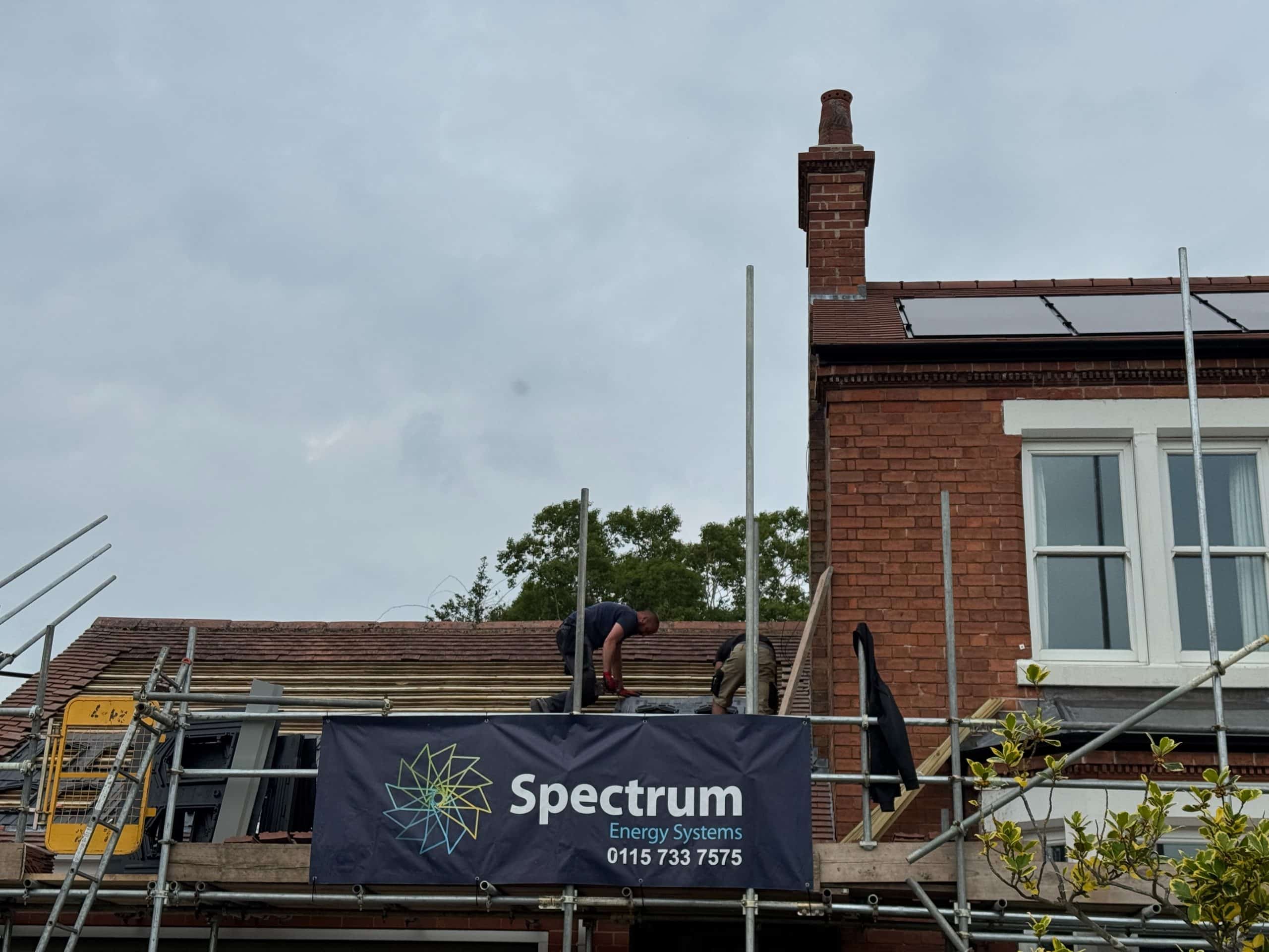 Solar panel installation process roof work, Spectrum crew preparing battens and in-roof trays from the scaffold (Spectrum Energy Systems UK installation)