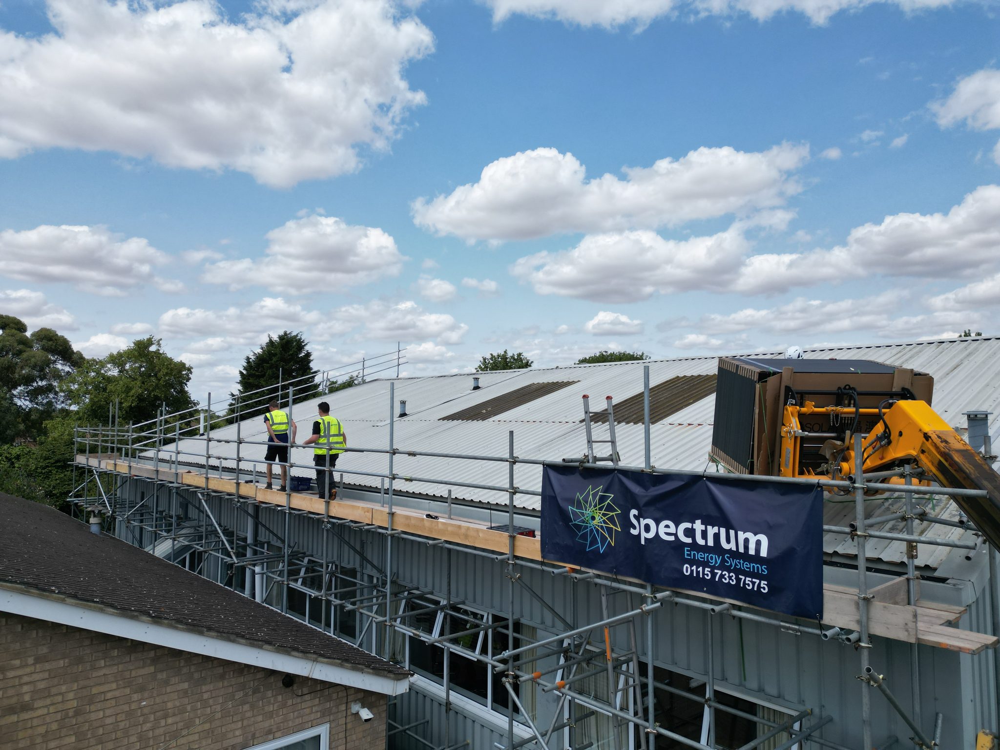 Spectrum Energy Systems crew installing extra solar panels next to a Feed-in Tariff system