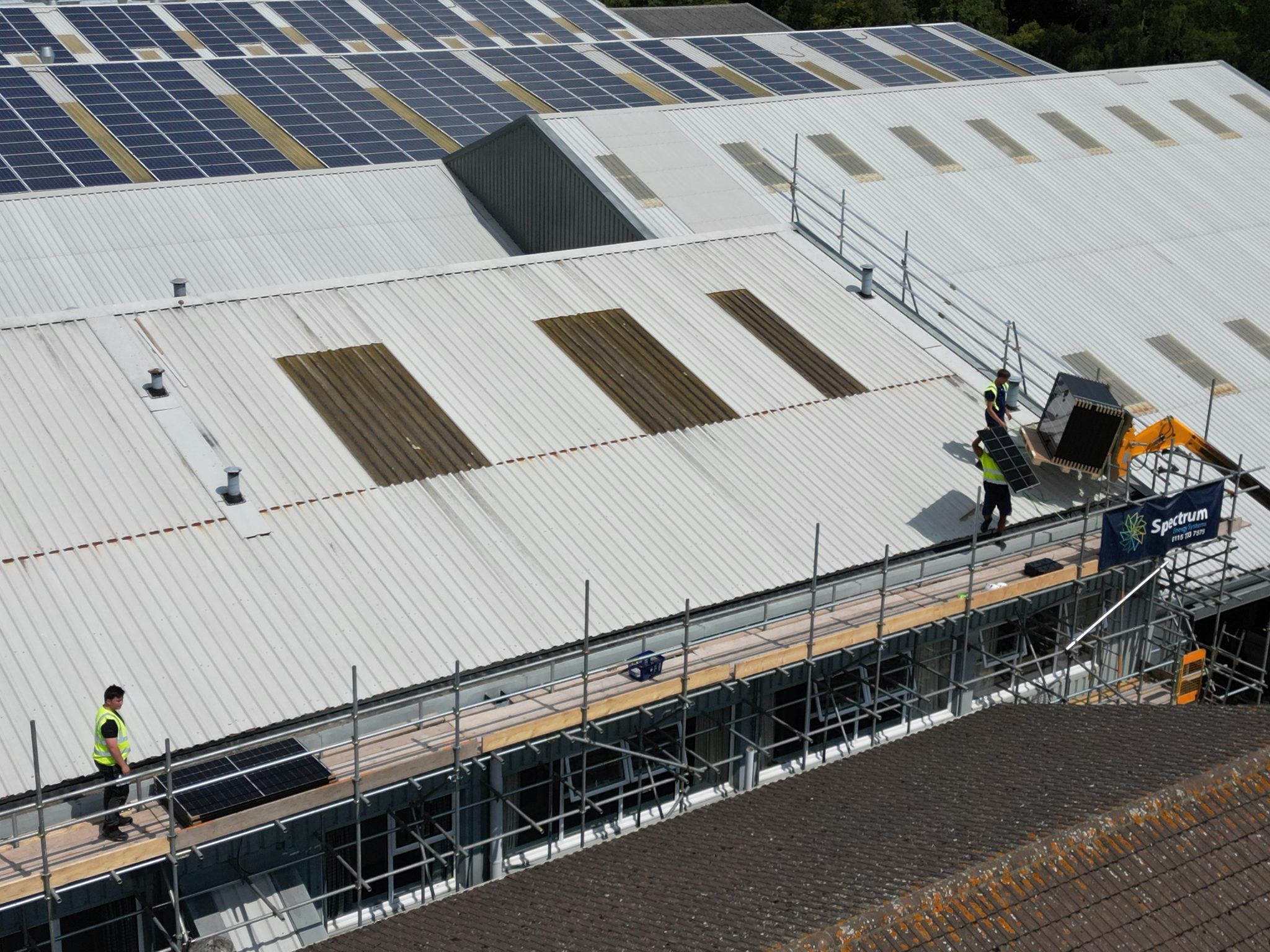 New solar panels going in beside an existing Feed-in Tariff array, Spectrum Energy Systems crew on site